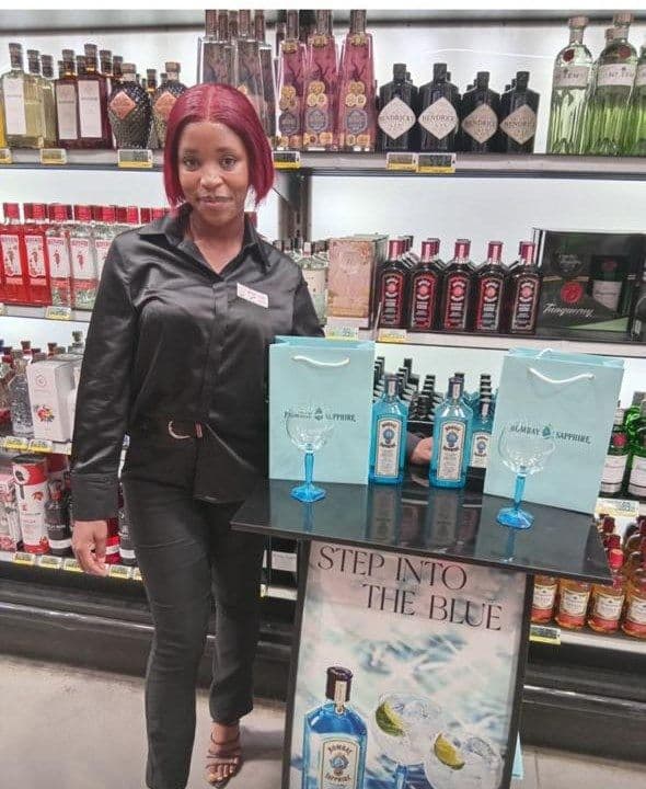 The tasting table with gift bags and copa glasses lined up, the promoter standing alongside