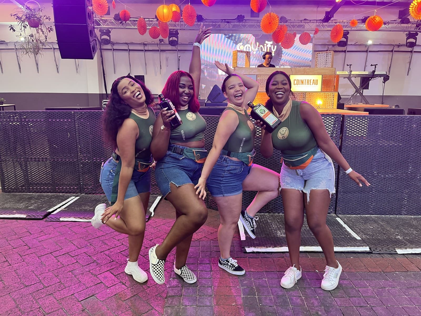 Four Jägermeister ambassadors dancing with bottles in hand at a club night