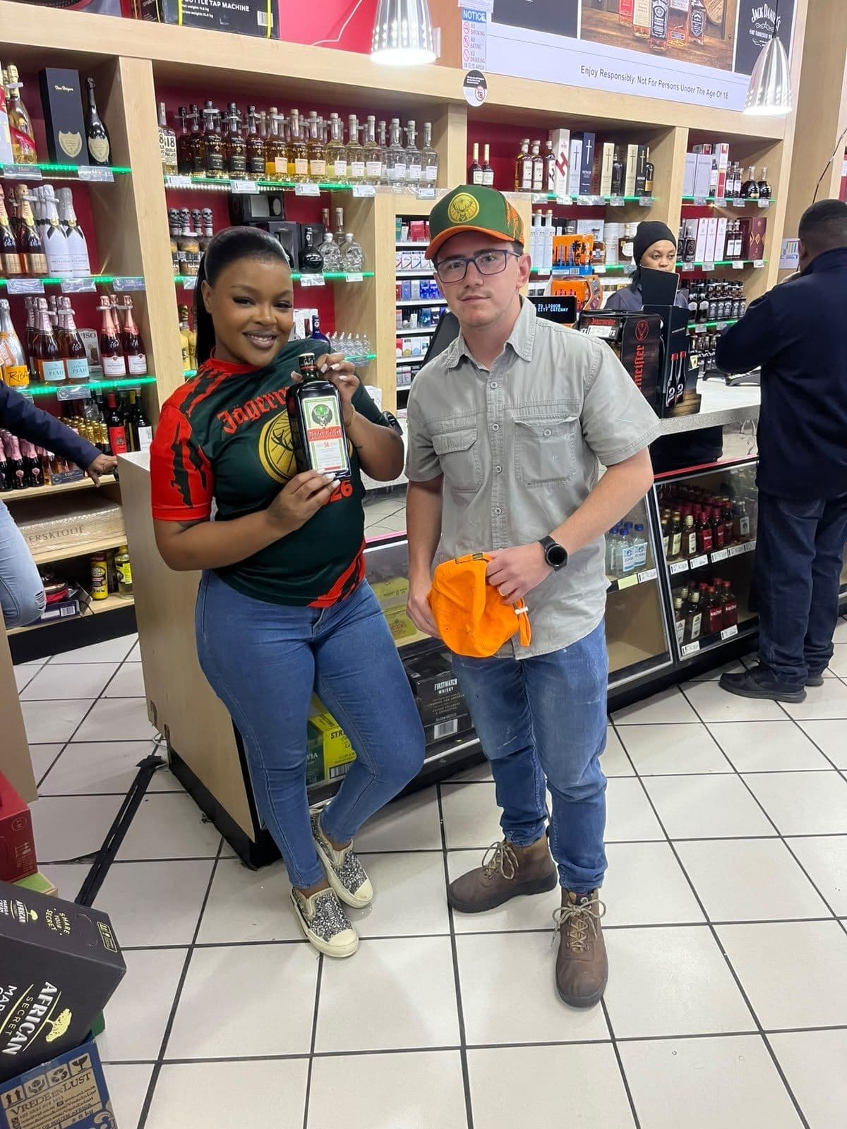 A promoter with the bottle mid-pitch to an older shopper at the display