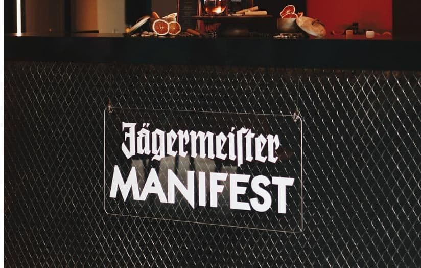 The Jägermeister Manifest sign panel up close, white lettering on black mesh